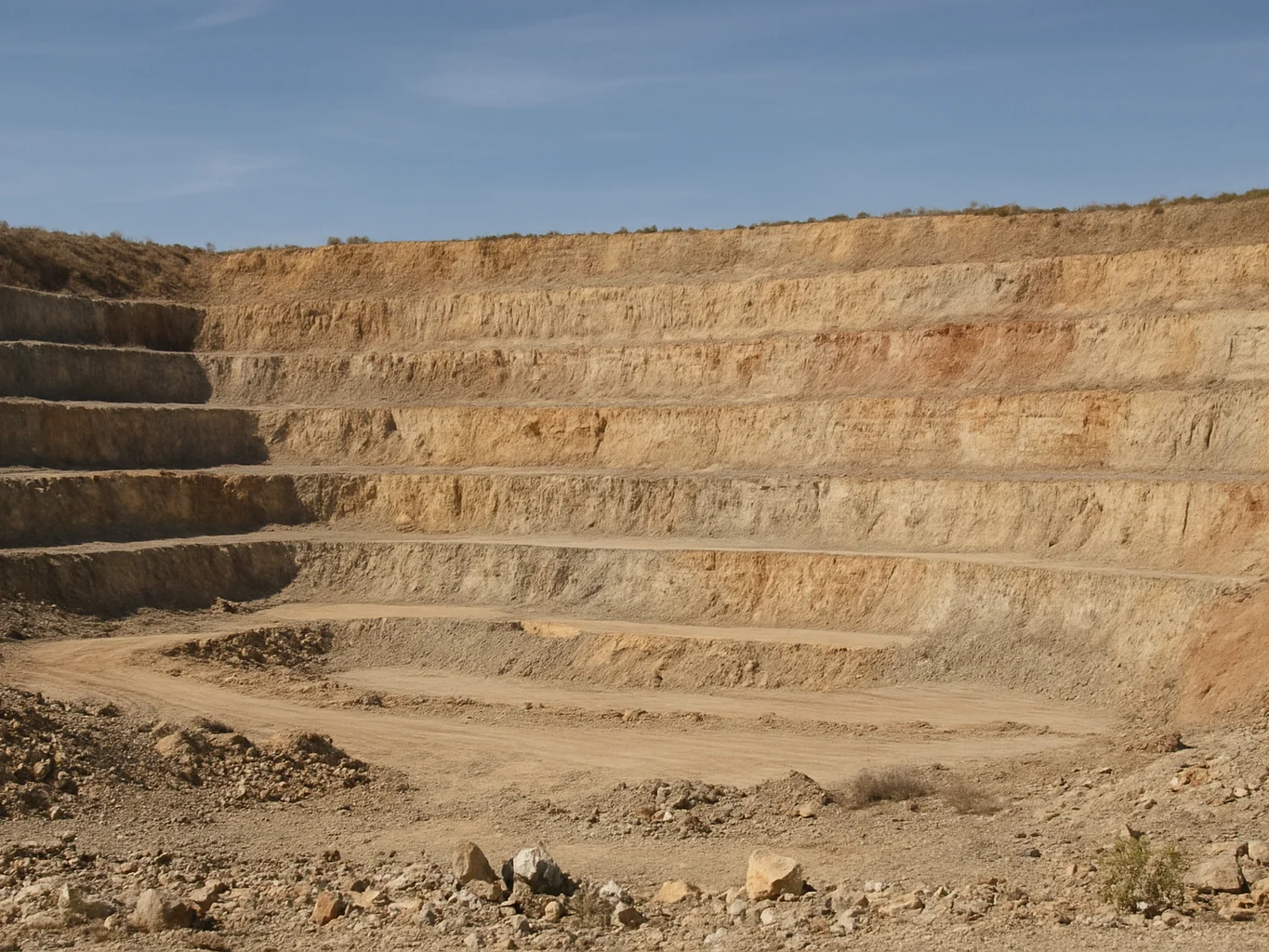 Wide environmental view of an open quarry face at mid-morning, la
